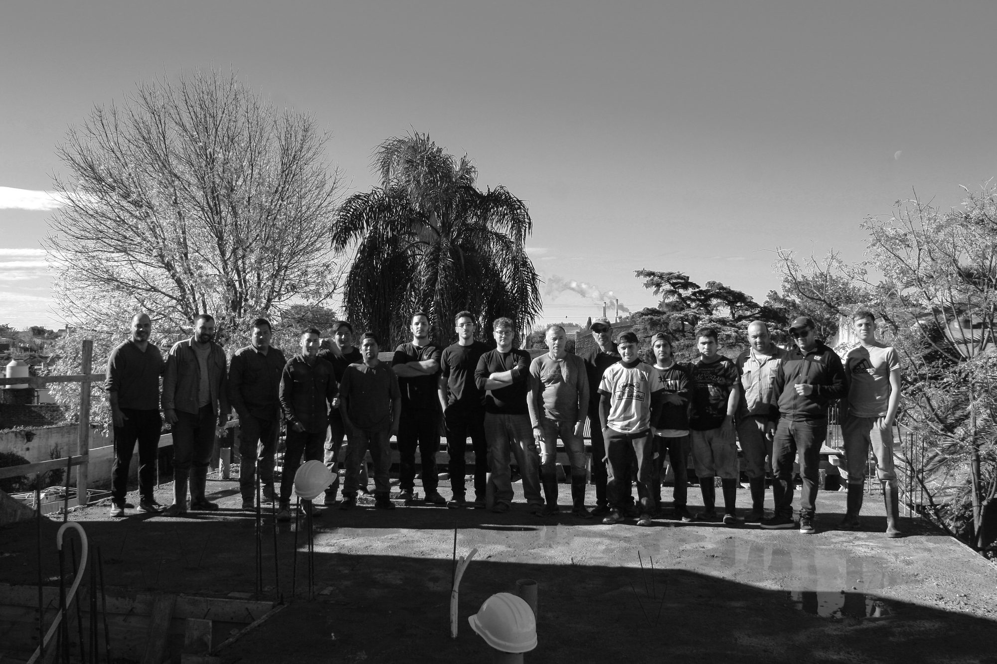 Fotografía grupal en blanco y negro del equipo completo de Grupo JC Arquitectura sobre la losa